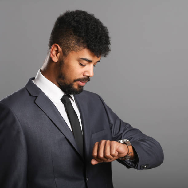 Business person looking at his wristwatch. About 30 years old man, Mixed race with beard.